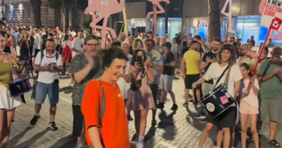 PROPOZIMI I VITIT  I rrethuar nga flamingot  i riu merr guximin dhe i propozon të dashurës në mes të protestës